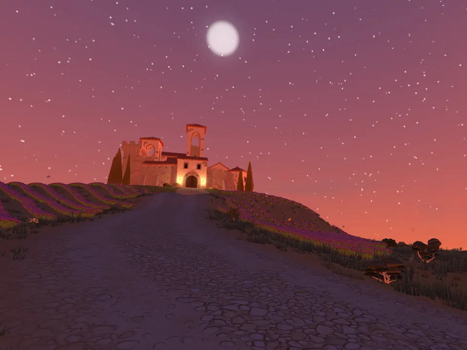 The castle lit on its hill at dusk, a road leading up to it